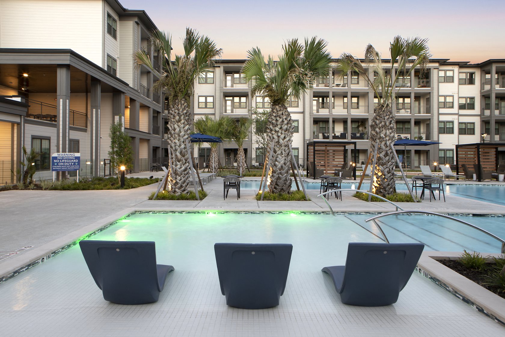 a resort-style pool with railing and lounge chairs at a senior apartment community